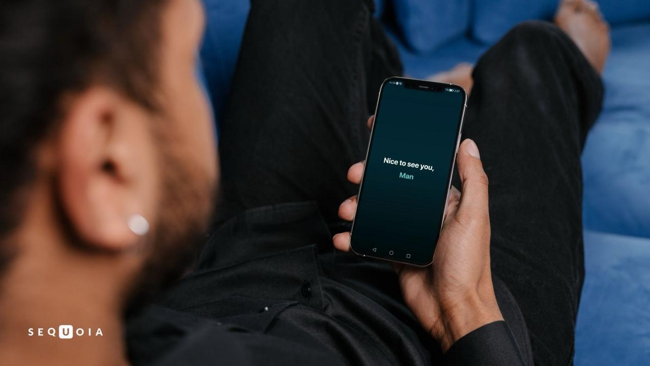 Мужчина держит Android телефон с запущенной Sequoia и приветственным экраном